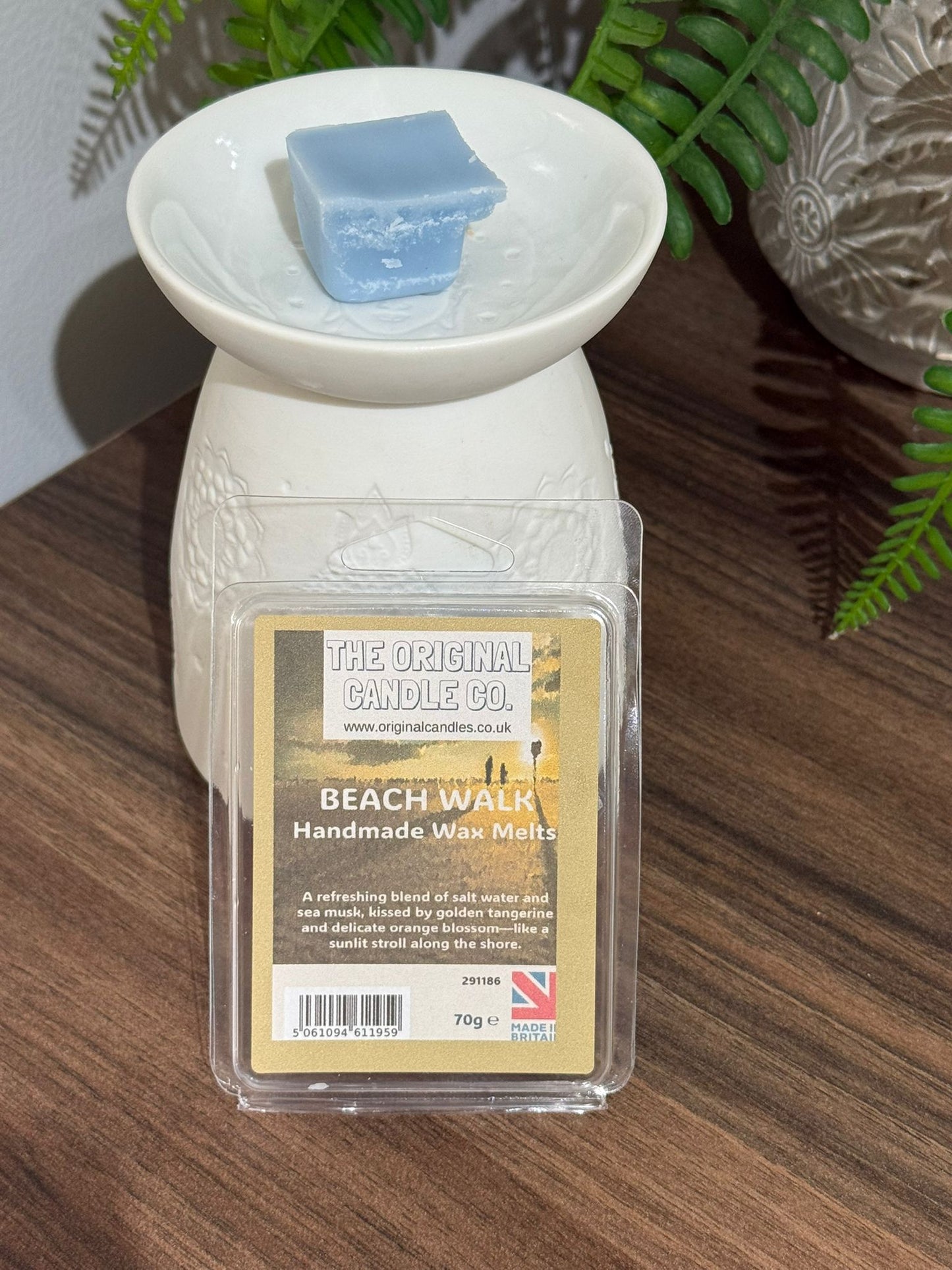 Wax melt container with a label on a wooden surface The Original Candle Company