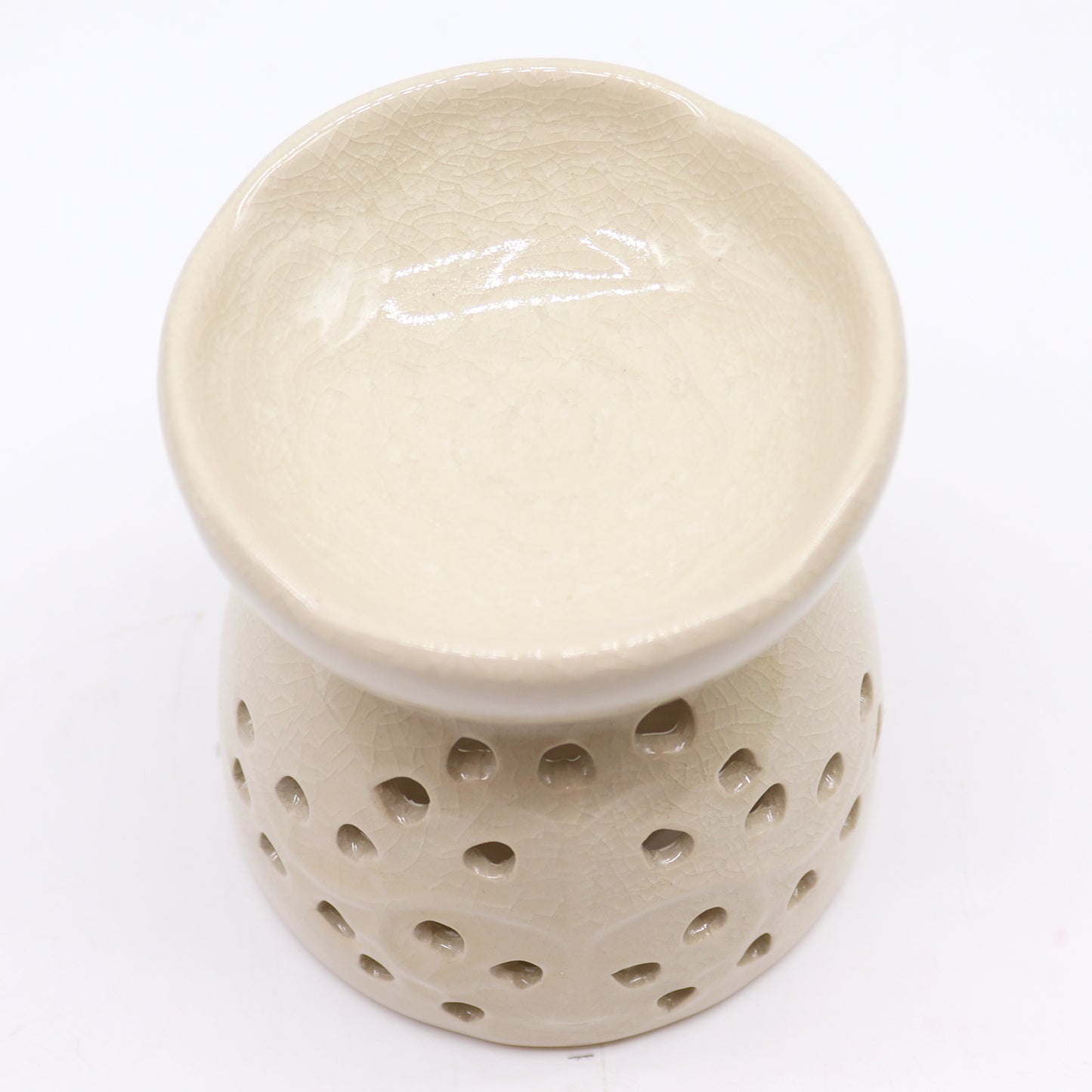 Sourced by The Original Candle Company and featuring a classic tree of life design with a highly decorative glaze in ivory, this oil burner and wax warmer will make an attractive decoration in any room. This image highlights the oil wells decorative floral design.