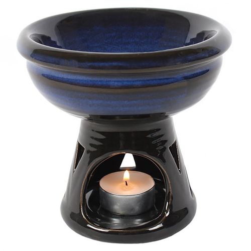 Carefully sourced by The Original Candle Company, this glazed oil burner has a beautiful ombre colour effect of blue to black. Triangle cutout details at the base are highlighted when a lit tealight is placed underneath the bowl. Suitable for use with fragrance oils or wax melts. This image shows the tealight cut-out.