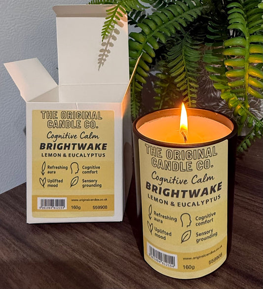 ADHD Autism Sensory candle from The Original Candle Co. with packaging on a wooden surface with a plant in the background
