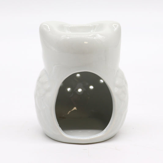 Carefully sourced by The Original Candle Company, this charming white owl-shaped oil burner is shown from an angle highlighting its cut-out section for tealight placement. Designed for essential oils and wax melts, it combines whimsical aesthetics with practical functionality for a cosy home ambiance.