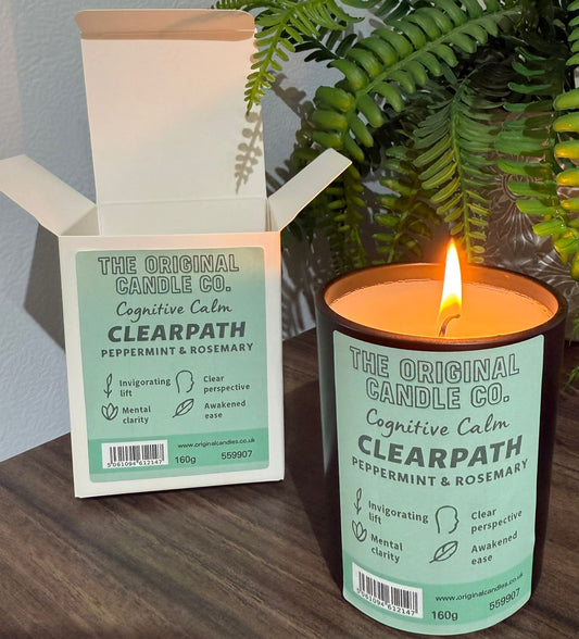 ADHD Autism Sensory candle from The Original Candle Co. with packaging on a wooden surface with a plant in the background
