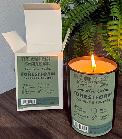 ADHD Autism Sensory candle from The Original Candle Co. with packaging on a wooden surface with a plant in the background