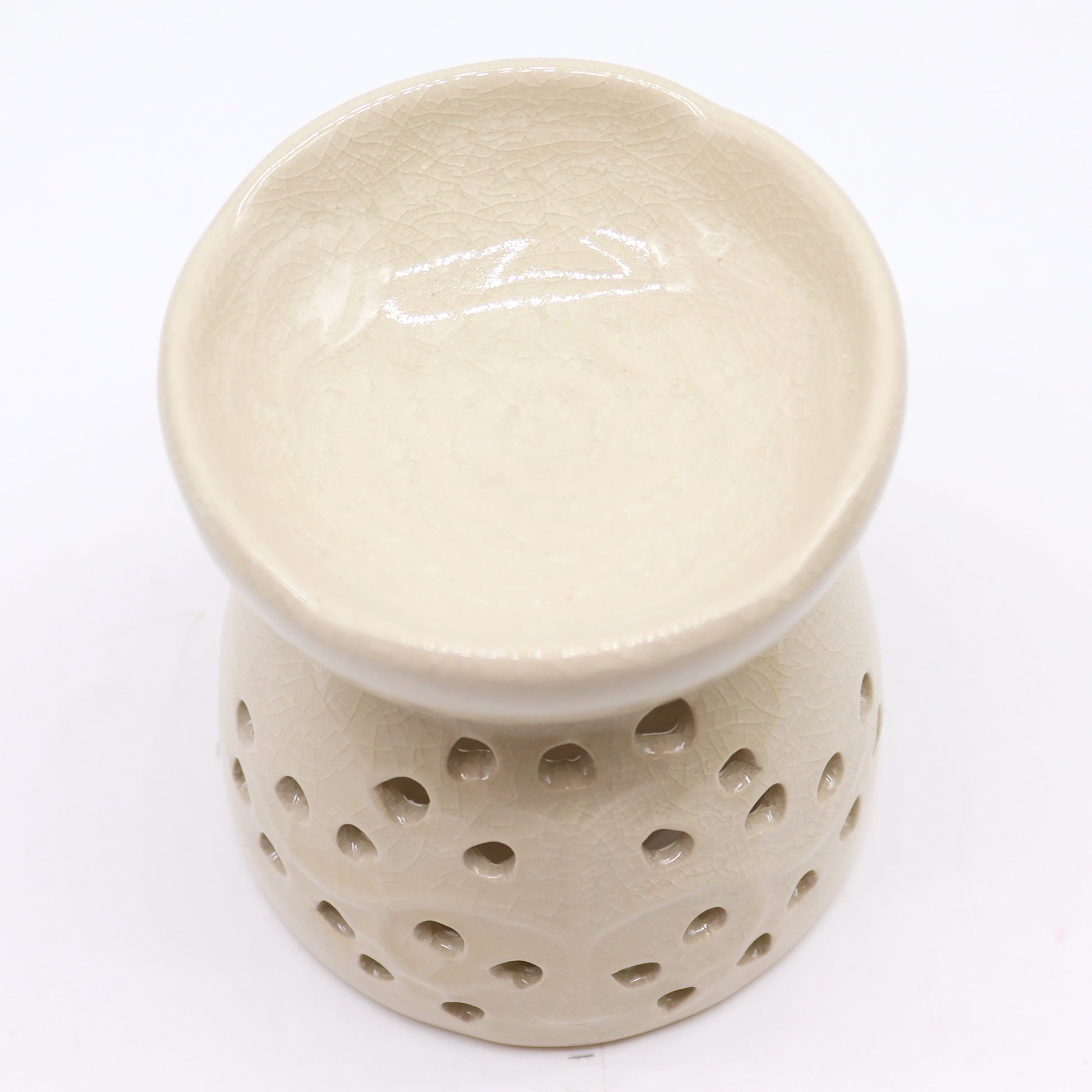 Sourced by The Original Candle Company and featuring a classic tree of life design with a highly decorative glaze in ivory, this oil burner and wax warmer will make an attractive decoration in any room. This image highlights the oil wells decorative floral design.