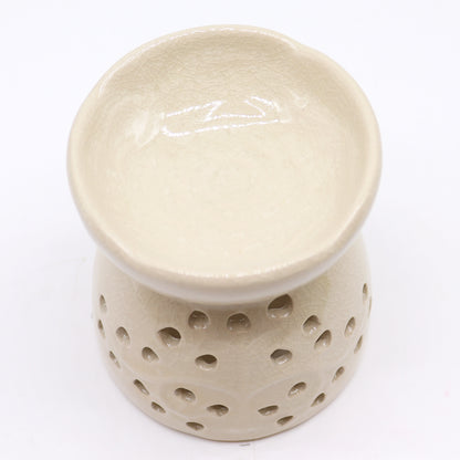 Sourced by The Original Candle Company and featuring a classic tree of life design with a highly decorative glaze in ivory, this oil burner and wax warmer will make an attractive decoration in any room. This image highlights the oil wells decorative floral design.