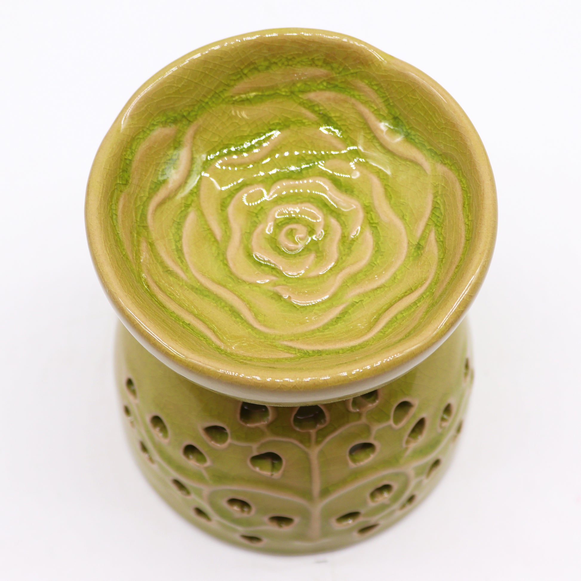 Carefully sourced by The Original Candle Company and featuring a classic tree of life design with a highly decorative glaze in lime, this oil burner and wax warmer will make an attractive decoration in any room. Image shows the oil well with its highly decorative flower design.