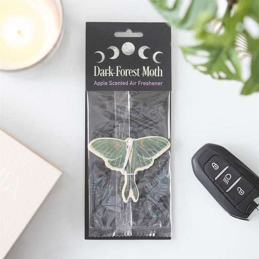 A luna moth apple scented car air freshener inside its packaging.
