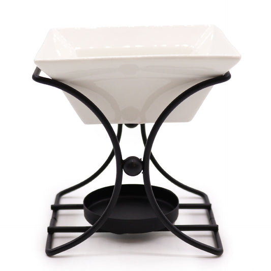 Carefully sourced by The Original Candle Company, this modern square ceramic oil burner features a striking black metal frame. Designed for essential oils and wax melts, it blends sleek aesthetics with practical functionality, elevating home fragrance rituals.