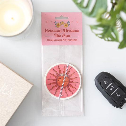 Floral fragranced celestial dreams car air freshener depicting the sun in a circular pink and orange design.