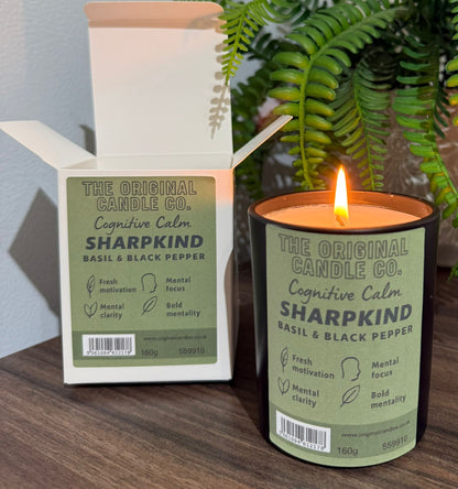 ADHD Autism Sensory candle from The Original Candle Co. with packaging on a wooden surface with a plant in the background