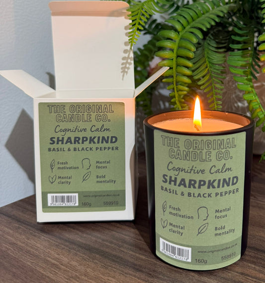 ADHD Autism Sensory candle from The Original Candle Co. with packaging on a wooden surface with a plant in the background