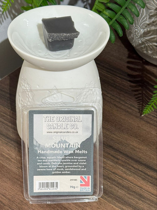 Wax melt container with a label on a wooden surface The Original Candle Company