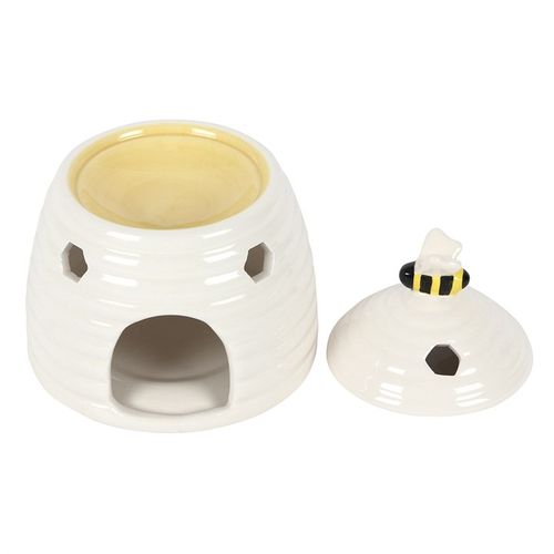Specially sourced by The Original Candle Company. This ceramic oil burner and wax warmer comes in the shape of an adorable white beehive with a sweet bee on the lid. Honeycomb-shaped cutouts finish off this unique style. Image shows the lid removed where the oil or wax melts are placed.