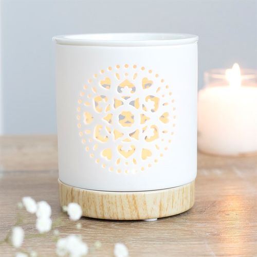 Carfully sourced by The Original Candle Company. This white ceramic oil burner features a cutout mandala design with a wood-effect ceramic base. Place fragrance oil or wax melts into the built-in dish with a standard tealight inside to fill the home with calming fragrance.
