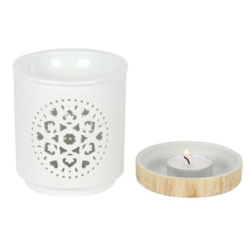 This white ceramic oil burner features a cutout mandala design with a wood-effect ceramic base. Place fragrance oil or wax melts into the built-in dish with a standard tealight inside to fill the home with calming fragrance. Image depicts the wood effect base showing where the tealight sits.