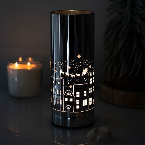 Christmas Village Electric Aroma Lamp from The Original Candle Co. casts a soft, festive glow over its intricate holiday design while gently diffusing your favourite fragrance oils—perfect for creating a cosy winter atmosphere.